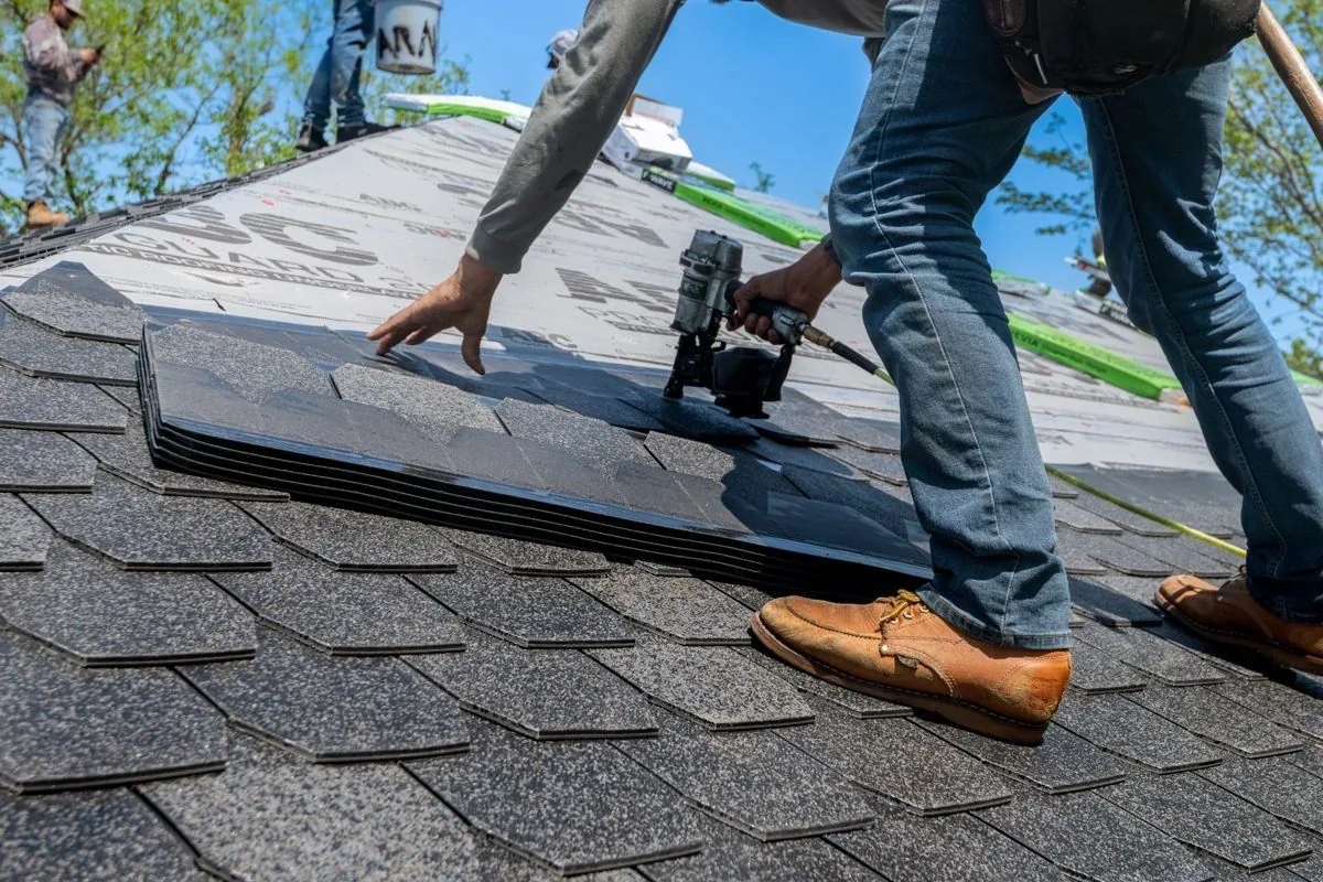Roofer installing asphalt shingles